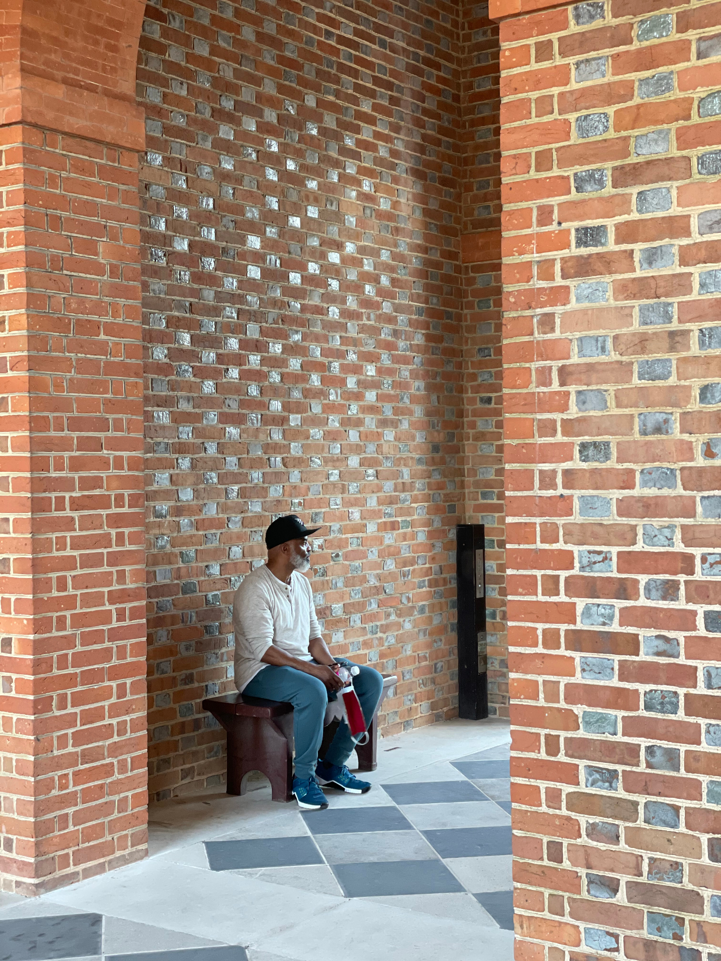 Curtis E. Spence seated in a brick alcove — Williamsburg, VA